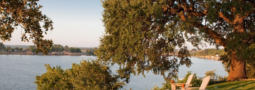 Two chairs at the edge of the lake at the Inn on Lake Granbury