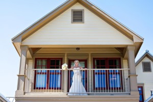 Texas waterfront wedding venues - the bride overlooks a railing at the inn