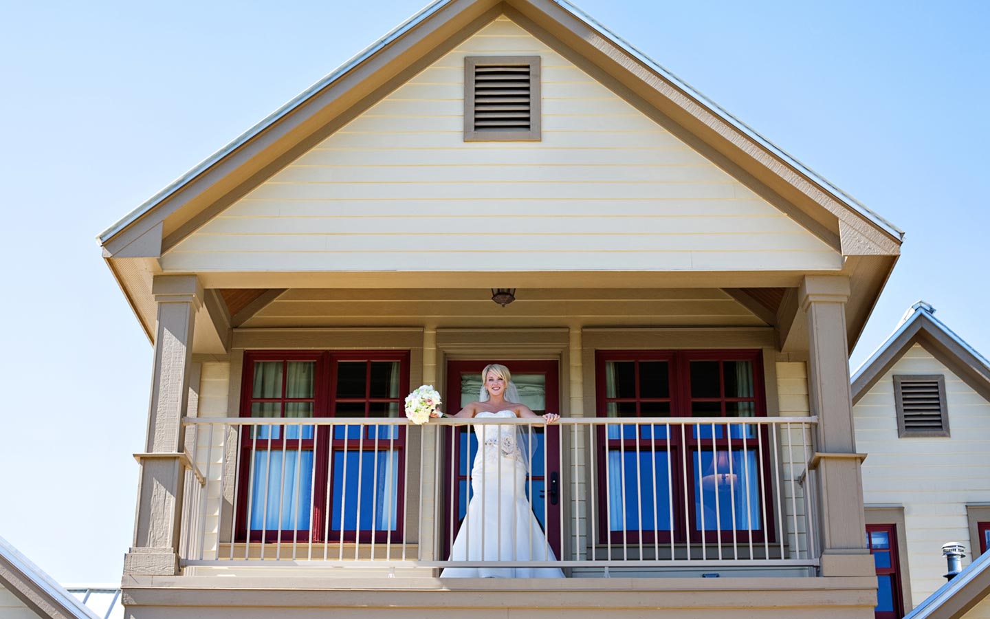 Texas waterfront wedding venues - the bride overlooks a railing at the inn