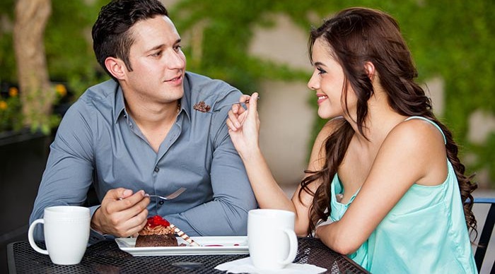 Woman feeding man chocolate cake