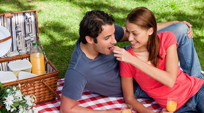 Woman feeding man during picnic