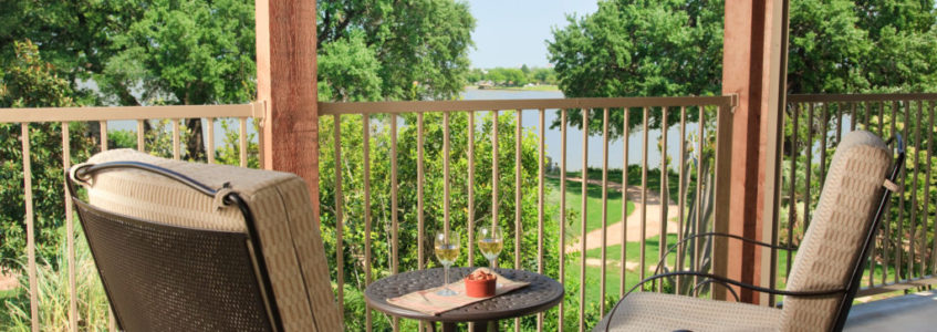Deck chairs with table with wine on it overlooking lake granbury