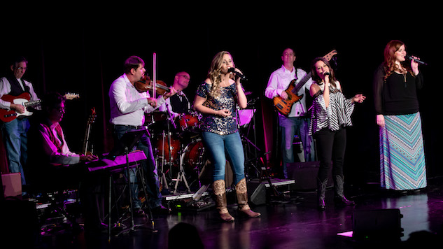 Band performing on softly glowing purple stage