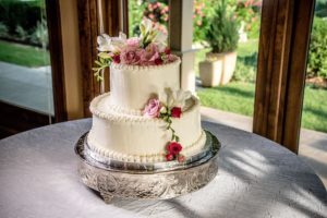 Wedding cake sitting on table with large windows behind