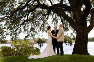 Elopement under a tree in front of lake