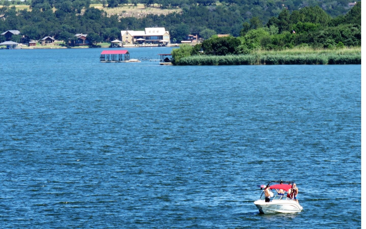 View of Lake Granbury with deep green trees and boats in the water