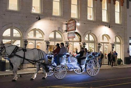 Couple taking a carriage ride through downtown Granbury at night.