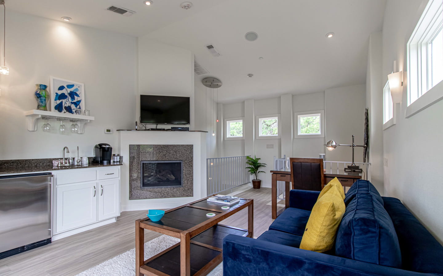 Spacious living room with couches, wet bar, fireplace, and flatscreen TV