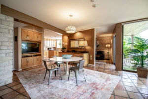 Room with tile floors and a small four person table with a TV