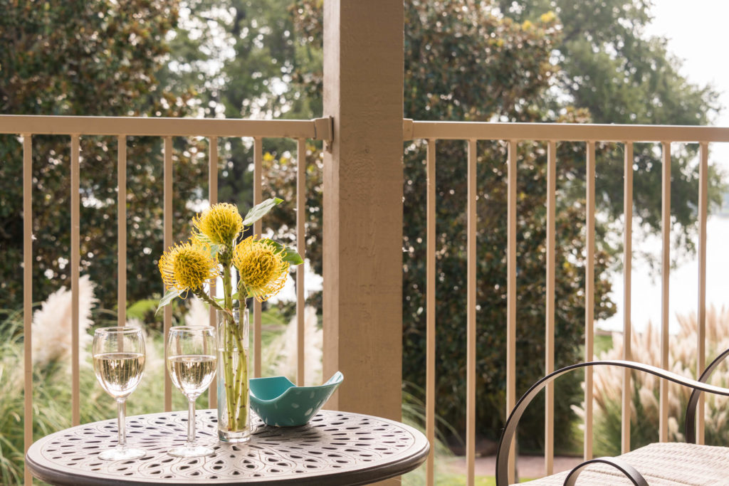 Lake loft patio with table and chairs and fresh yellow flowers in a vase