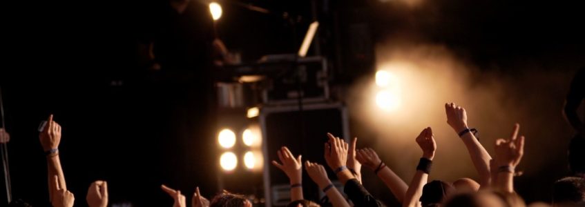 Audience at a concert with hands in the air