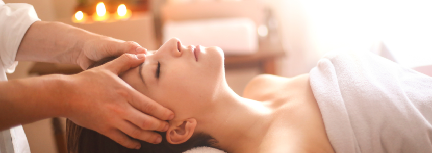 A woman lays on a massage table